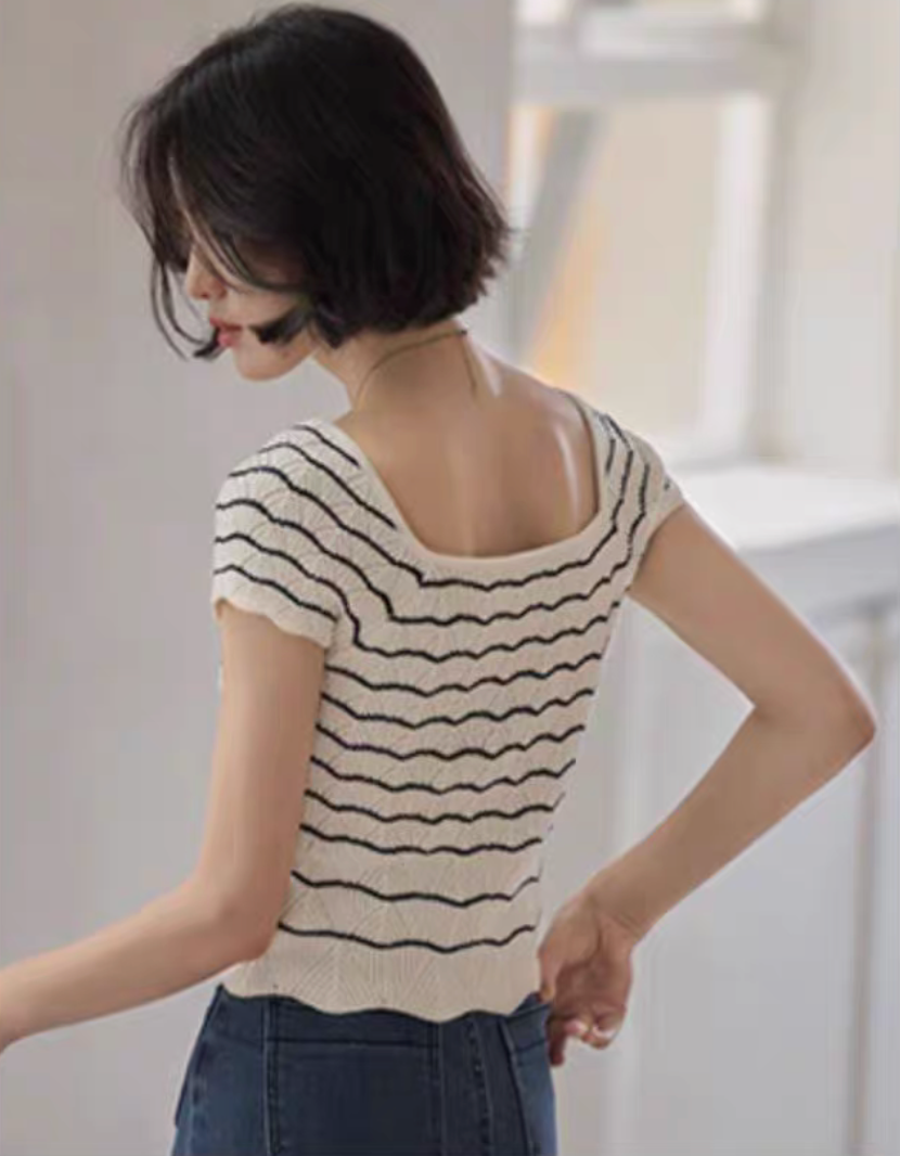 Back view of black and white striped knit top showing square neckline and fitted silhouette with wavy hem detail