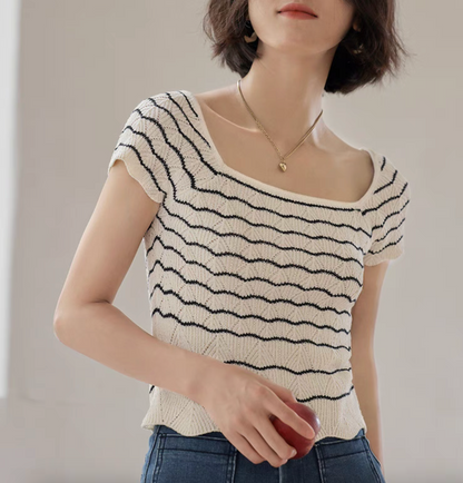 Close-up of black and white striped knit top highlighting openwork texture and soft stretch fabric detail
