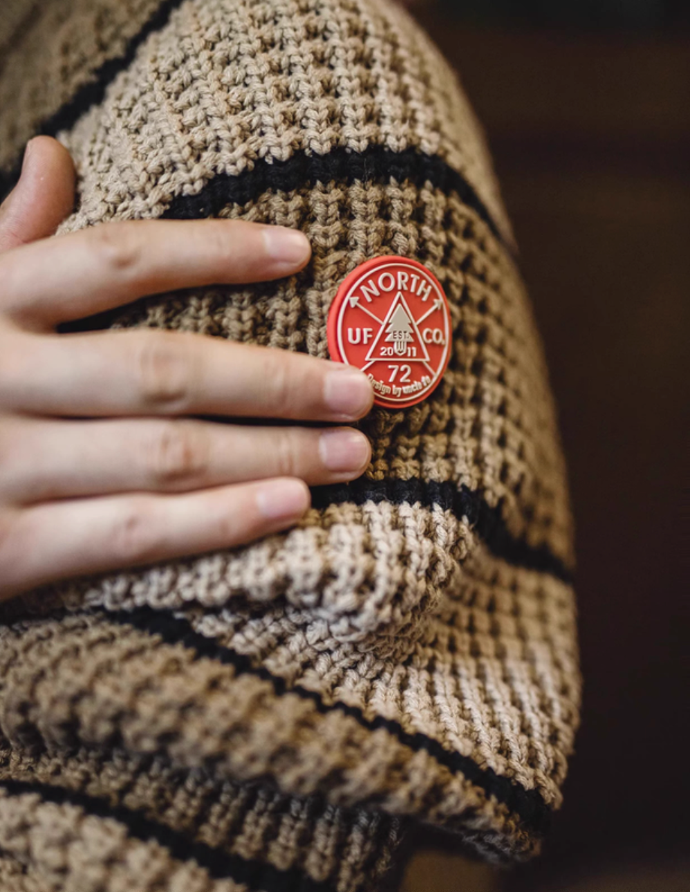 Waffle Ridge Stripe Sweater Khaki close-up of sleeve logo patch highlighting textured knit pattern and premium detailing