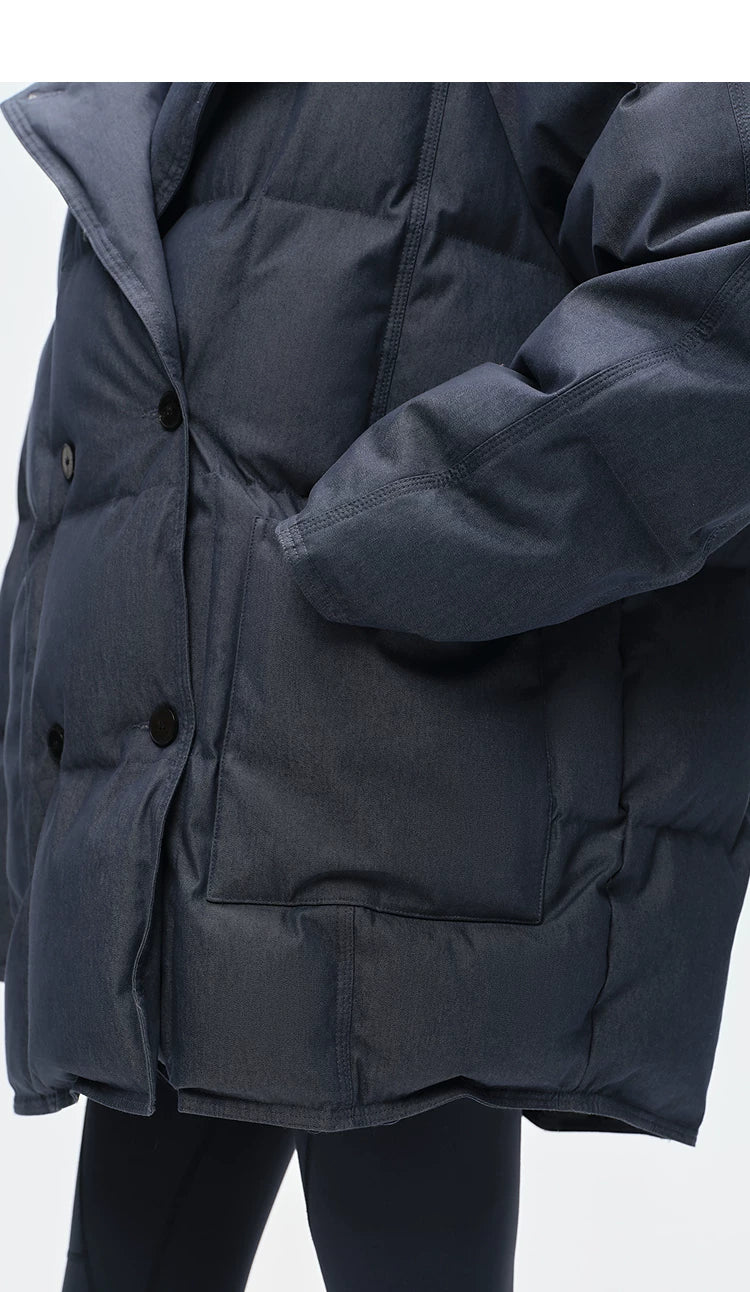 Close-up of double-breasted buttons and deep patch pocket on washed denim down coat