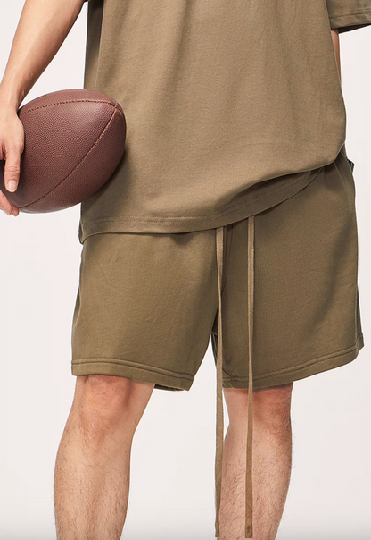 Washed Heavyweight Terry Shorts Brown close-up lifestyle view with football showing fabric texture and drawstring detail