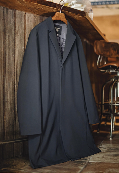 Side angle of model wearing navy waterproof Mac coat