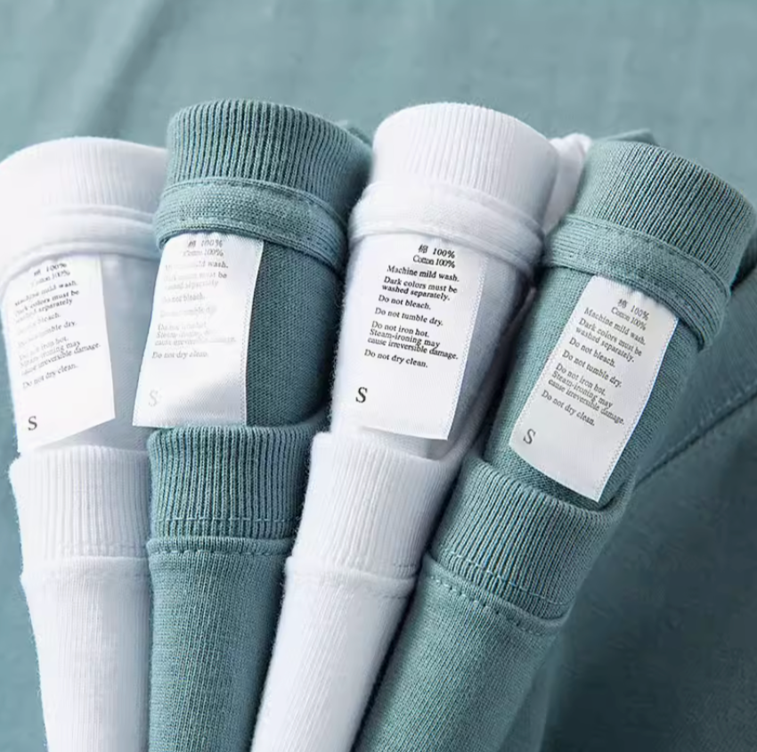 Weekend Vibes Tee ocean blue and white folded shirts showing fabric labels and cotton material detail