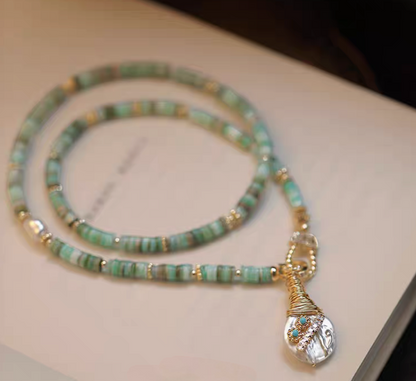 Whimsical Baroque Pearl and Shell Choker with turquoise beads and baroque pearl pendant displayed on surface