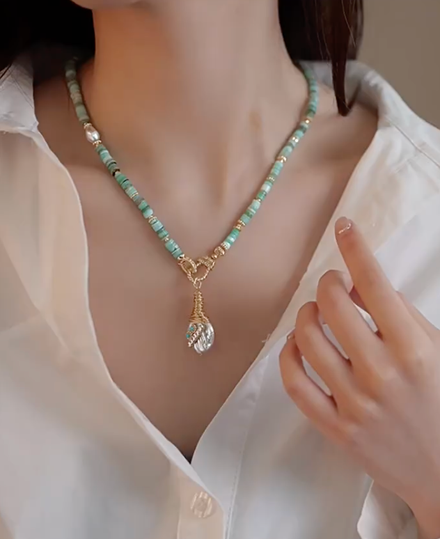 Model wearing Whimsical Baroque Pearl and Shell Choker with turquoise bead strand and baroque pearl pendant