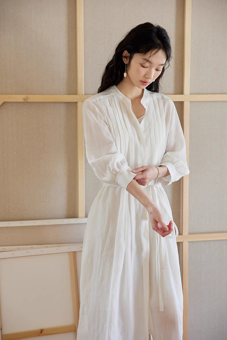 Close-up of White pleated midi dress highlighting hand-pressed pleats, waist tie detail, and soft breathable fabric texture