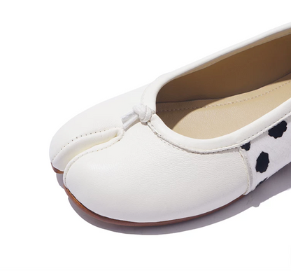 Close-up of a White leather tabi flat toe with knotted tie and piped topline