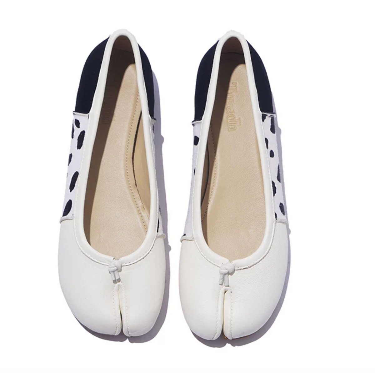 Top-down view of White tabi ballet flats showing the split toe, knotted leather tie, and sheepskin insoles