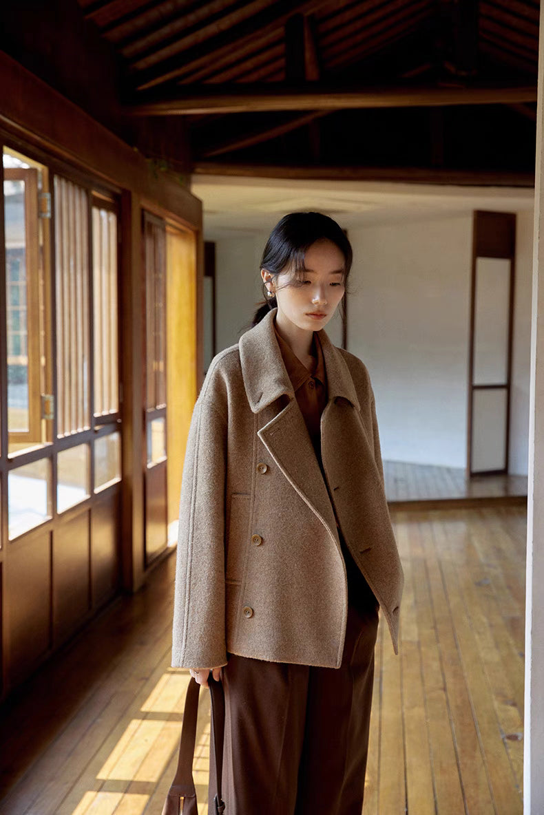 Front view of khaki short Willow Lane Wool Coat worn indoors, highlighting natural buttons, soft wool texture, and relaxed modern fit