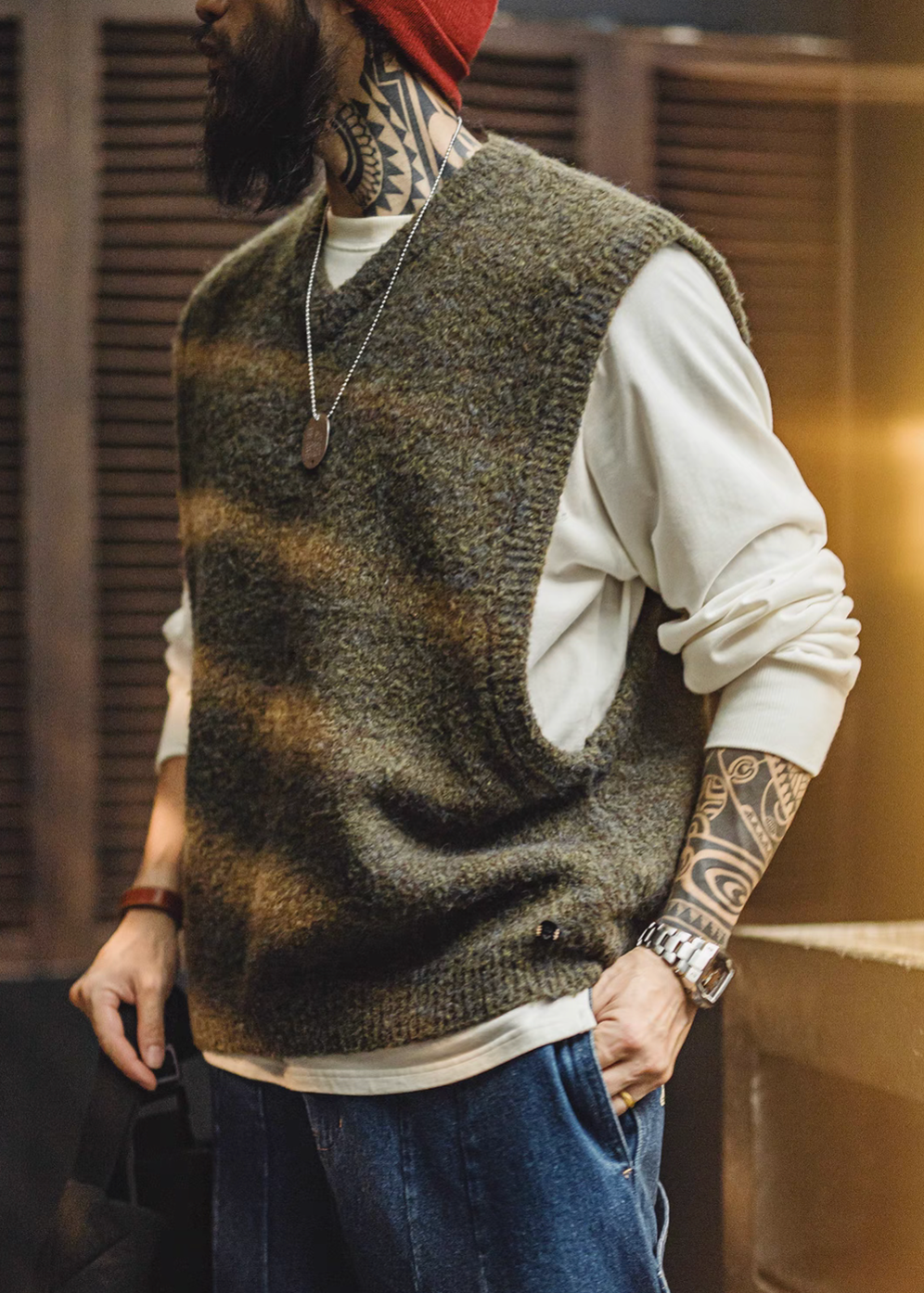 Side angle view of model wearing Woodland Retro V-Neck Vest in Moss Green styled with white shirt and jeans casual outfit