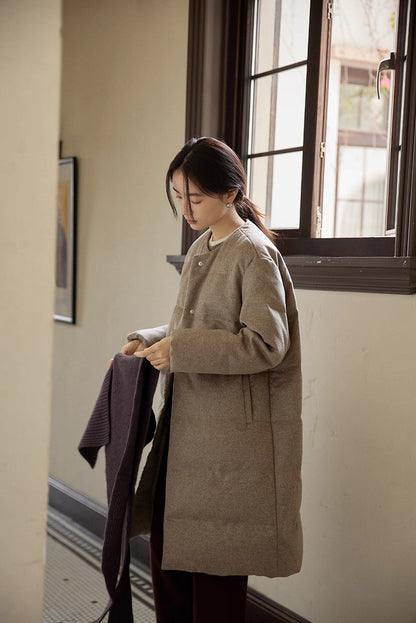 natural light portrait of wool-blend long down coat by window