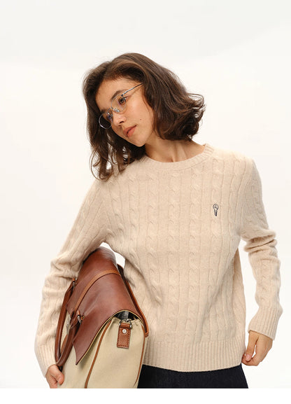 Model wearing beige almond wool sweater holding a canvas-leather bag