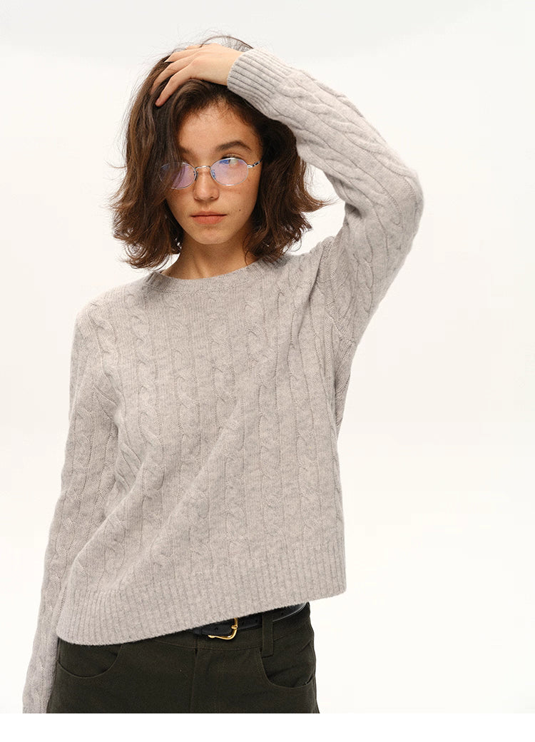 Model wearing light gray wool cable-knit sweater, front view with glasses
