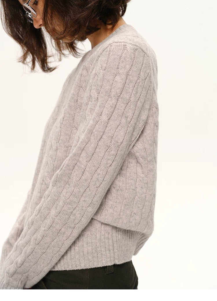 Side view of model wearing light gray wool sweater showing sleeve texture