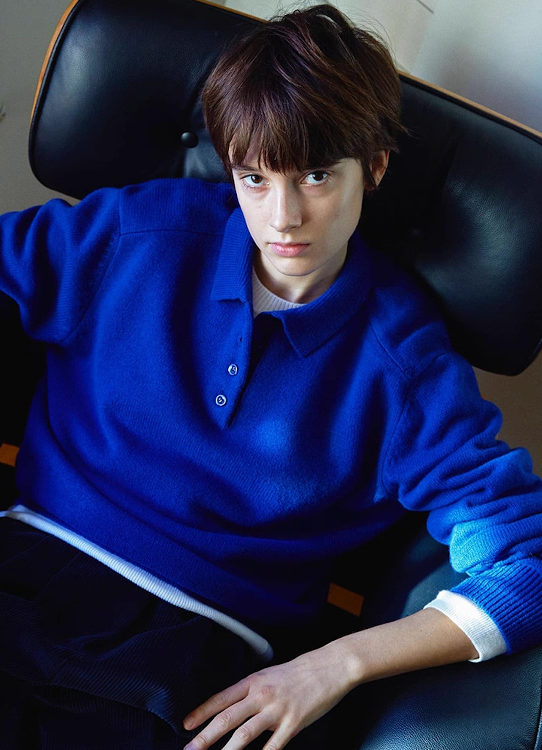 Model seated in dark blue wool cashmere polo sweater