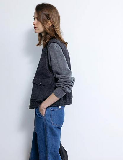 Side view of dark gray wool cashmere polo sweater layered with vest