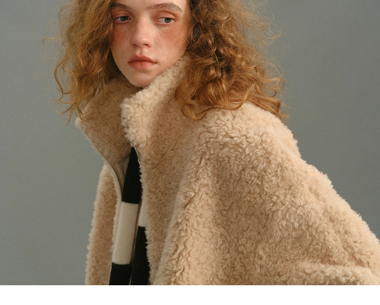 Detail shot of cream beige 100% wool high-neck jacket showing plush collar and wool texture