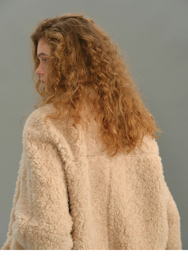 Back shoulder close-up of cream beige 100% wool jacket showing curly fleece texture