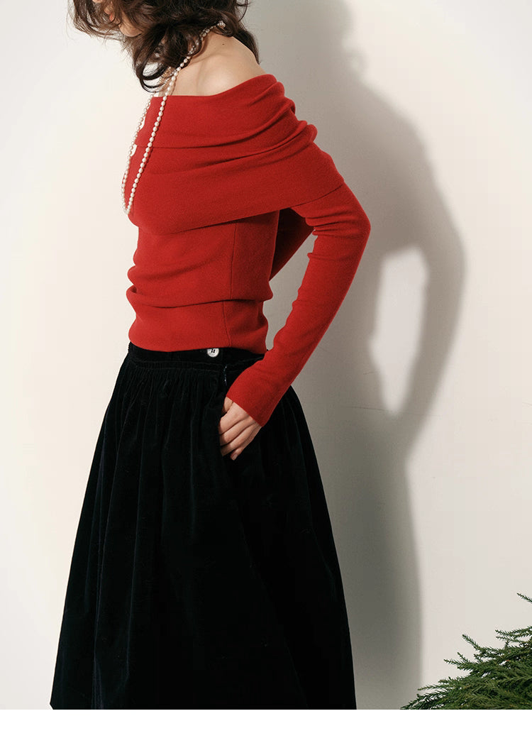 Side profile of red draped off-shoulder wool top showing layered fold neckline