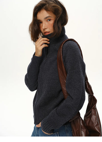 Close-up of deep navy wool zip collar sweater with high neck and brown leather shoulder bag