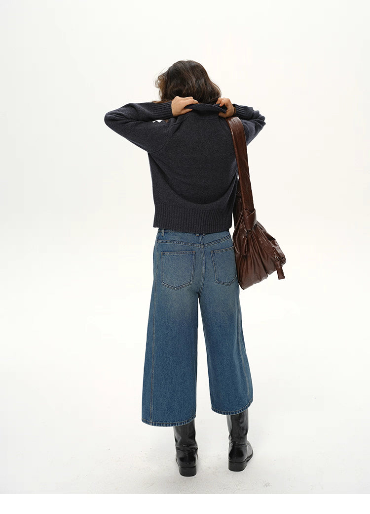 Back view of deep navy wool zip jacket showing ribbed hem and relaxed fit as model adjusts collar