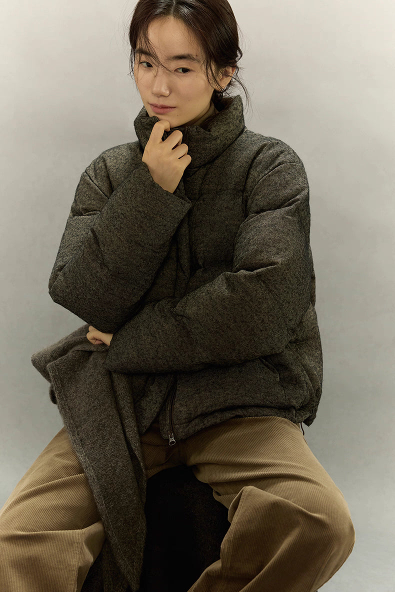 Close-up of woman touching the stand collar of a wool-blend down jacket.