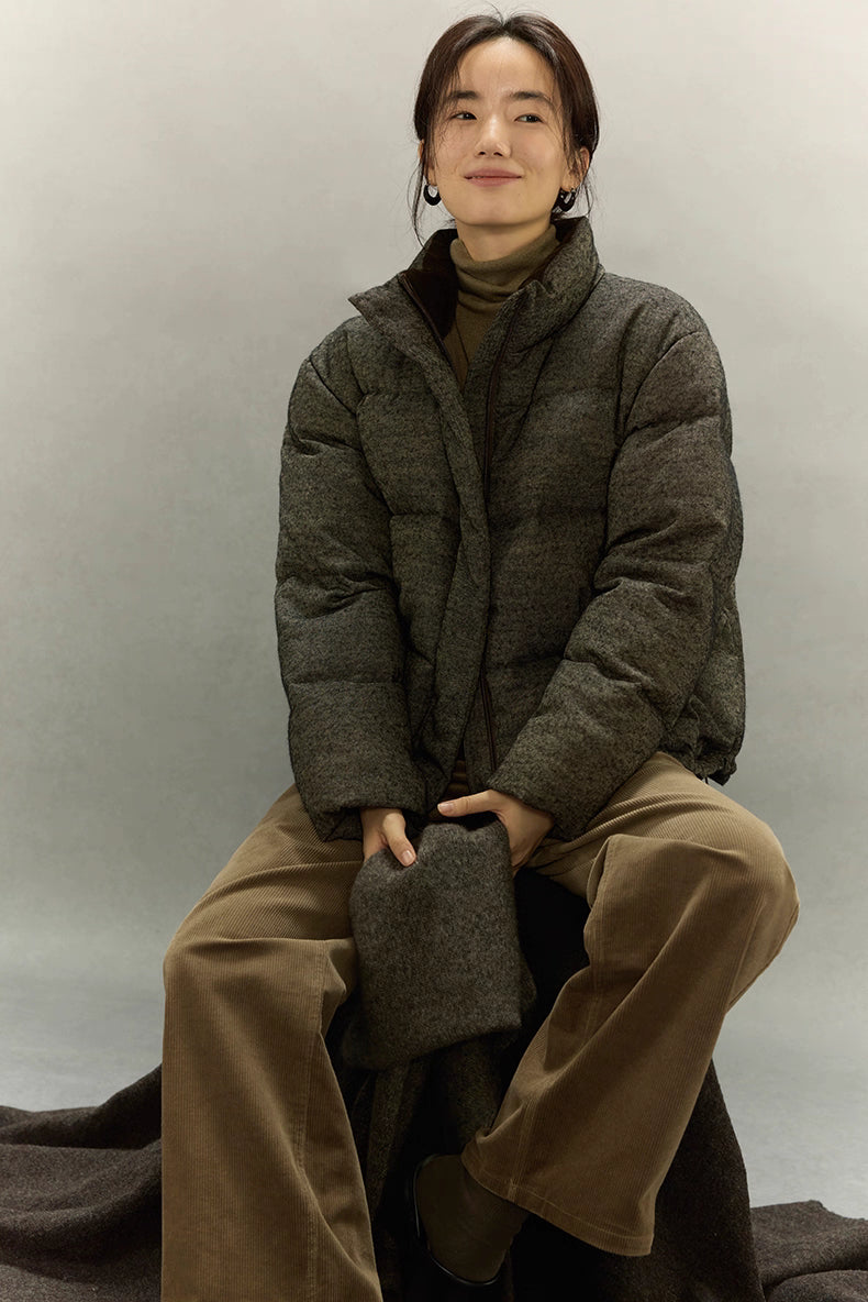 Woman wearing dark taupe wool-blend down jacket sitting with matching scarf.