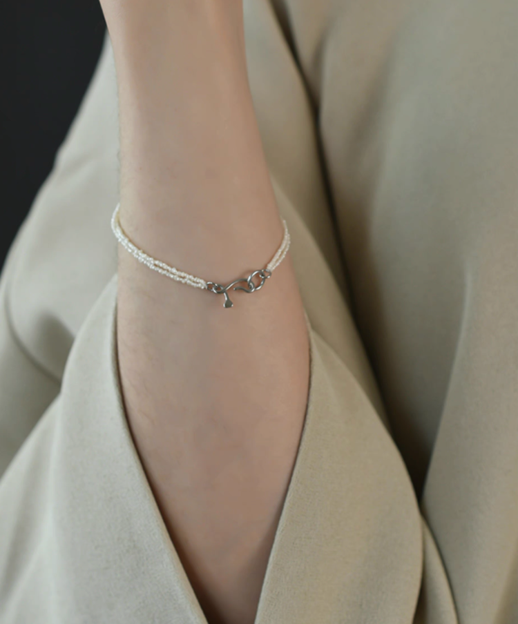 Wrapped Micro Pearl Bracelet with Hand-Formed Silver Clasp natural color minimalist bracelet worn with outfit on wrist